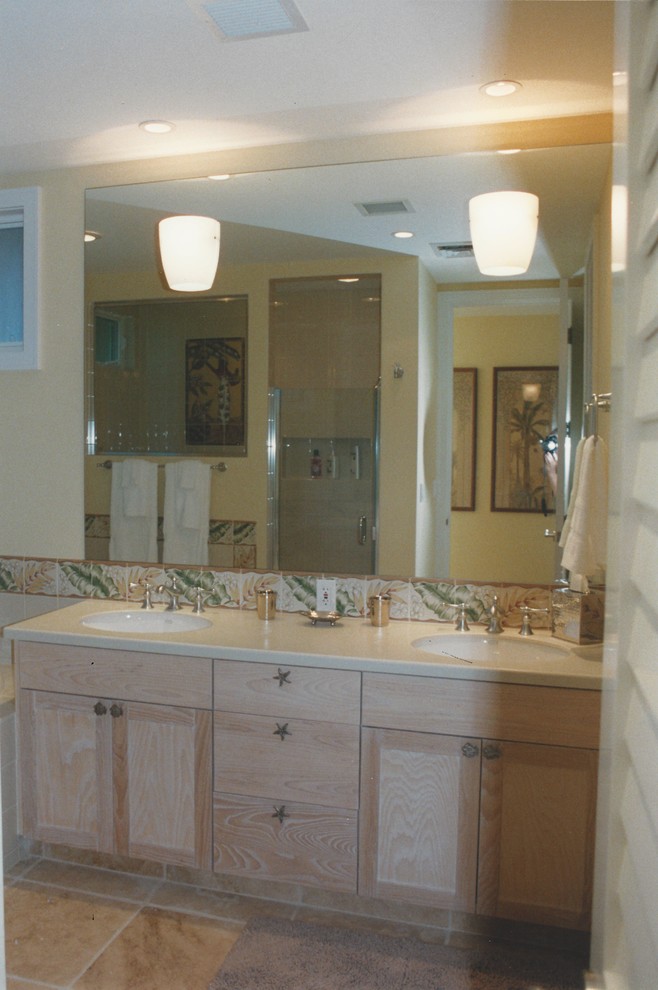 Inspiration for a large tropical 3/4 bathroom in San Francisco with shaker cabinets, light wood cabinets, a curbless shower, a two-piece toilet, multi-coloured tile, ceramic tile, yellow walls, travertine floors, an undermount sink and marble benchtops.