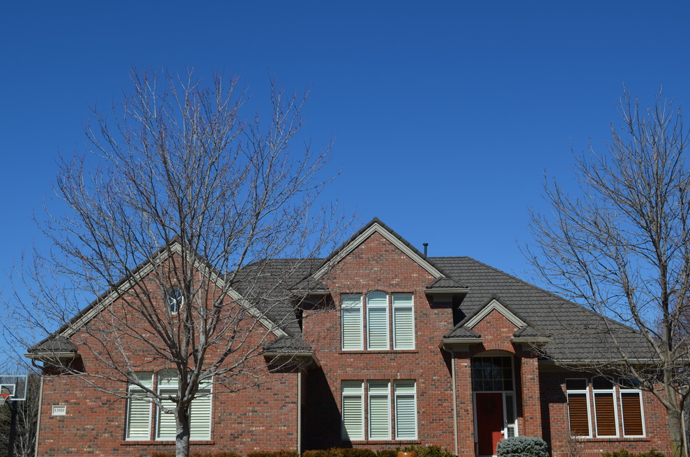 Large traditional two-storey brick red exterior in Omaha with a gable roof.