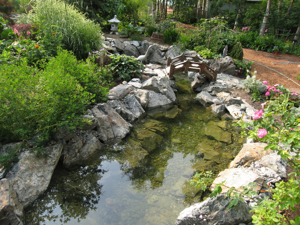 This is an example of a large transitional full sun backyard pond.