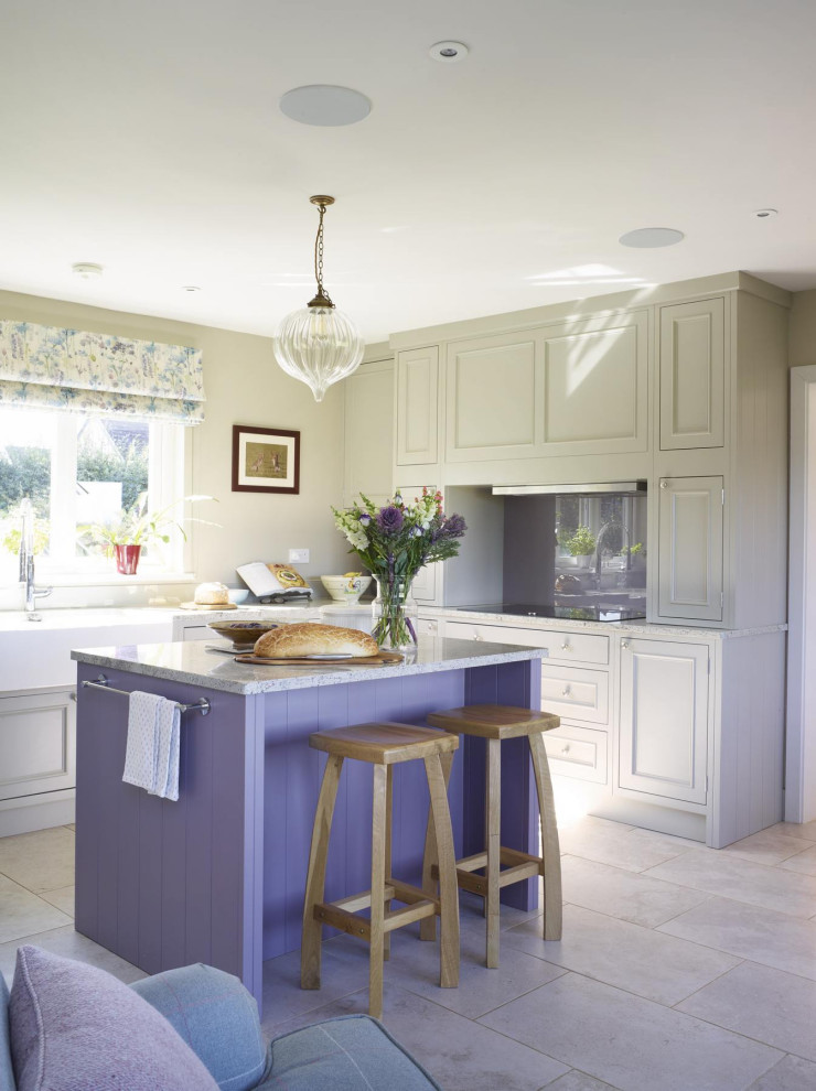 Photo of a mid-sized transitional l-shaped kitchen in Other with a farmhouse sink, recessed-panel cabinets, grey cabinets, glass sheet splashback, with island, grey floor and grey benchtop.