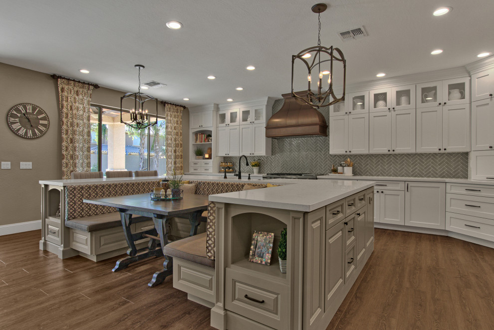 Large transitional u-shaped vinyl floor and brown floor eat-in kitchen photo with recessed-panel cabinets, white cabinets, quartz countertops, gray backsplash, ceramic backsplash, stainless steel appliances, an island and white countertops