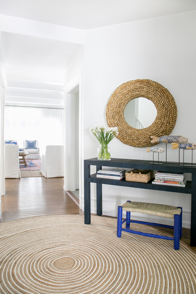 Photo of a mid-sized traditional foyer in New York with white walls, medium hardwood floors, a dutch front door, a glass front door and brown floor.