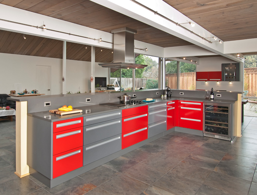 Photo of a large midcentury l-shaped open plan kitchen in San Francisco with an undermount sink, flat-panel cabinets, red cabinets, quartz benchtops, grey splashback, stone slab splashback, stainless steel appliances, slate floors and grey floor.