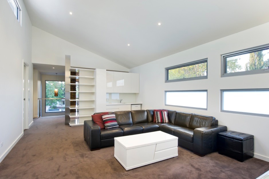 Inspiration for a large contemporary open concept living room in Melbourne with white walls and carpet.