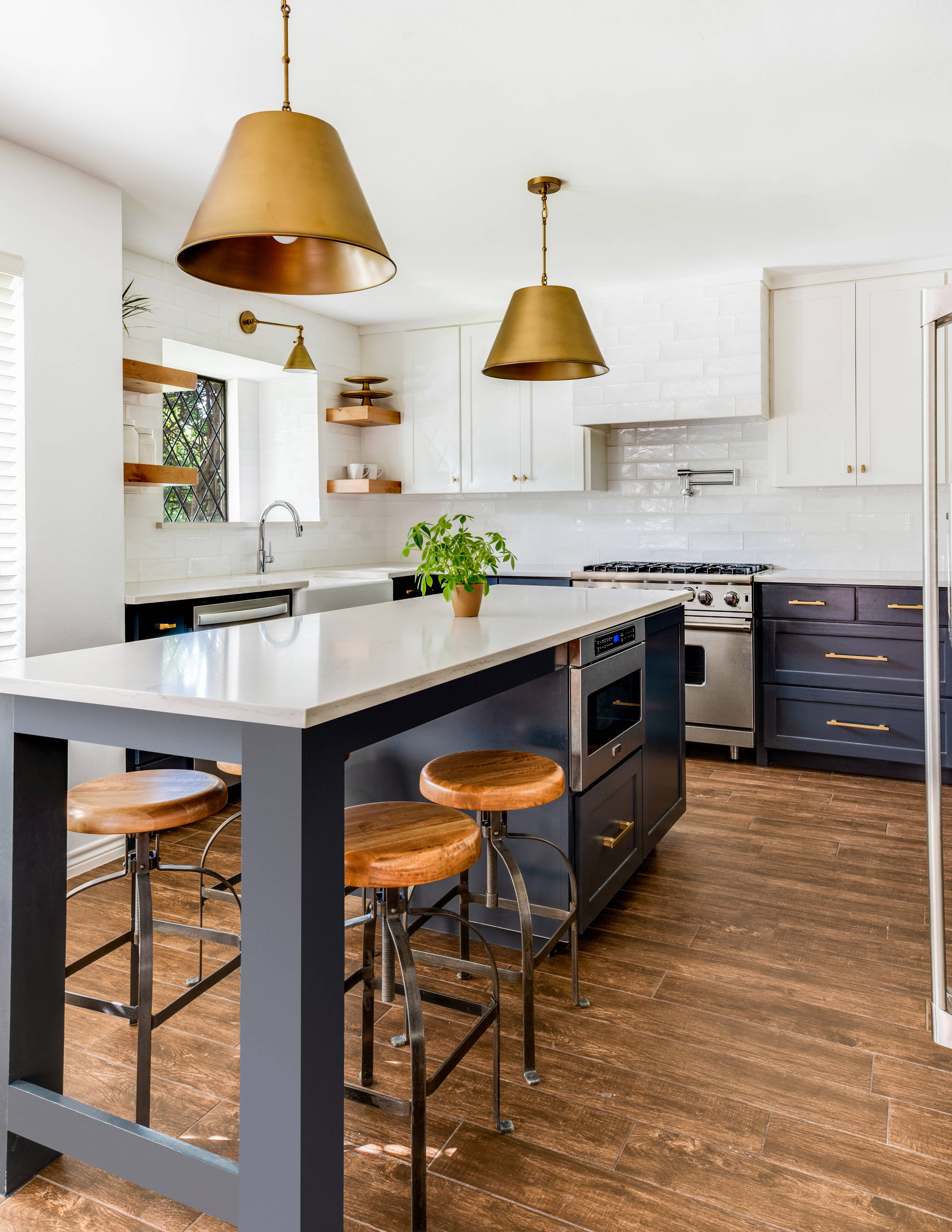 Example of a mid-sized transitional u-shaped medium tone wood floor and brown floor kitchen design in Dallas with a farmhouse sink, shaker cabinets, blue cabinets, quartz countertops, white backsplash