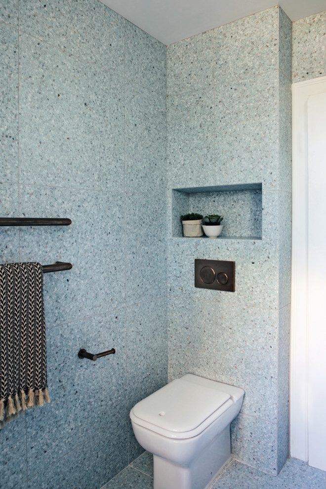 Photo of a mid-sized contemporary master bathroom in Sydney with open cabinets, white cabinets, an undermount tub, a shower/bathtub combo, blue tile, blue walls, terrazzo floors, a wall-mount sink and blue floor.
