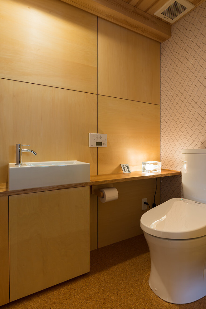 Photo of an asian powder room in Tokyo Suburbs with medium wood cabinets, a vessel sink, beige floor, flat-panel cabinets, brown walls, wood benchtops and brown benchtops.