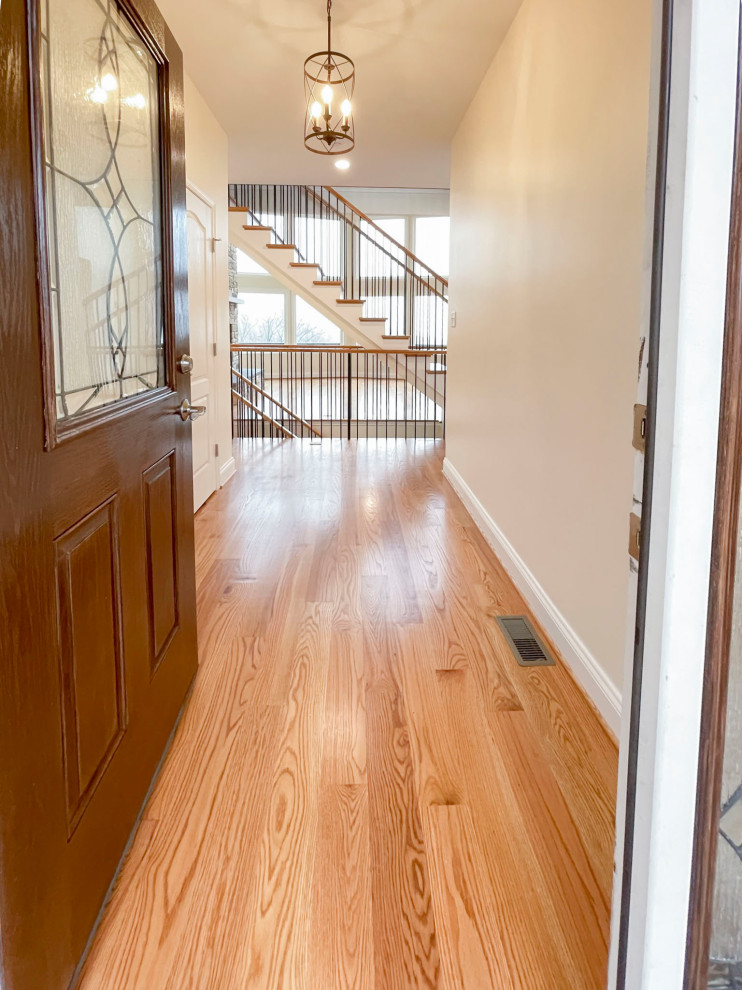 Large transitional wood floating staircase in DC Metro with wood risers, mixed railing and planked wall panelling.