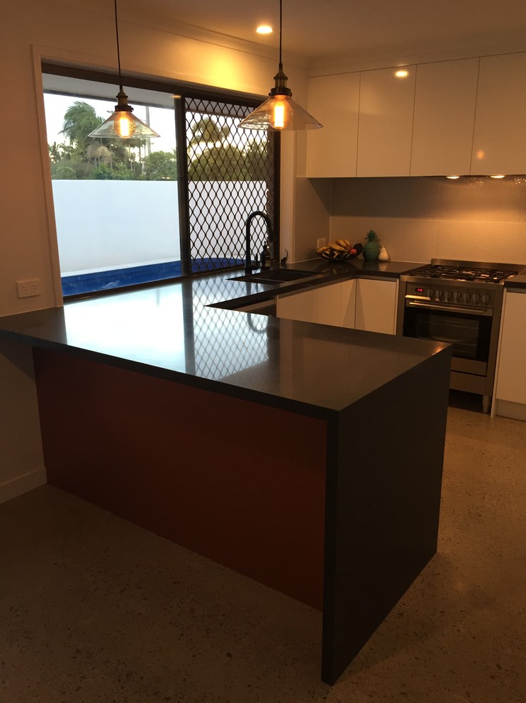This is an example of a large modern u-shaped kitchen pantry in Sunshine Coast with an undermount sink, open cabinets, white cabinets, quartz benchtops, grey splashback, ceramic splashback, stainless steel appliances, concrete floors and no island.