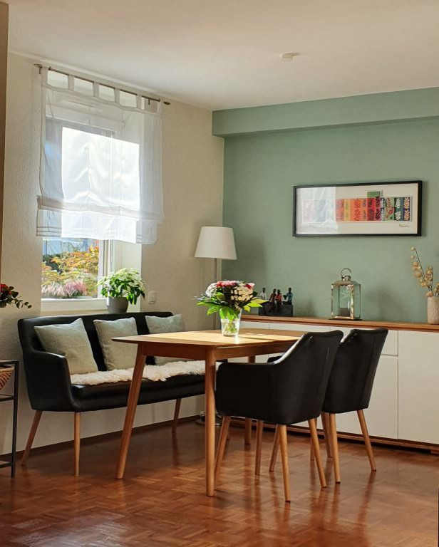 Источник вдохновения для домашнего уюта: маленькая гостиная-столовая в современном стиле с зелеными стенами, паркетным полом среднего тона, коричневым полом и обоями на стенах для на участке и в саду