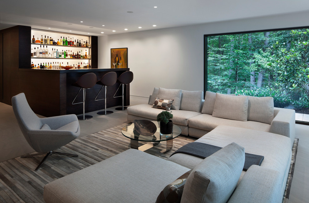 Large modern open concept family room in New York with a home bar, white walls and dark hardwood floors.