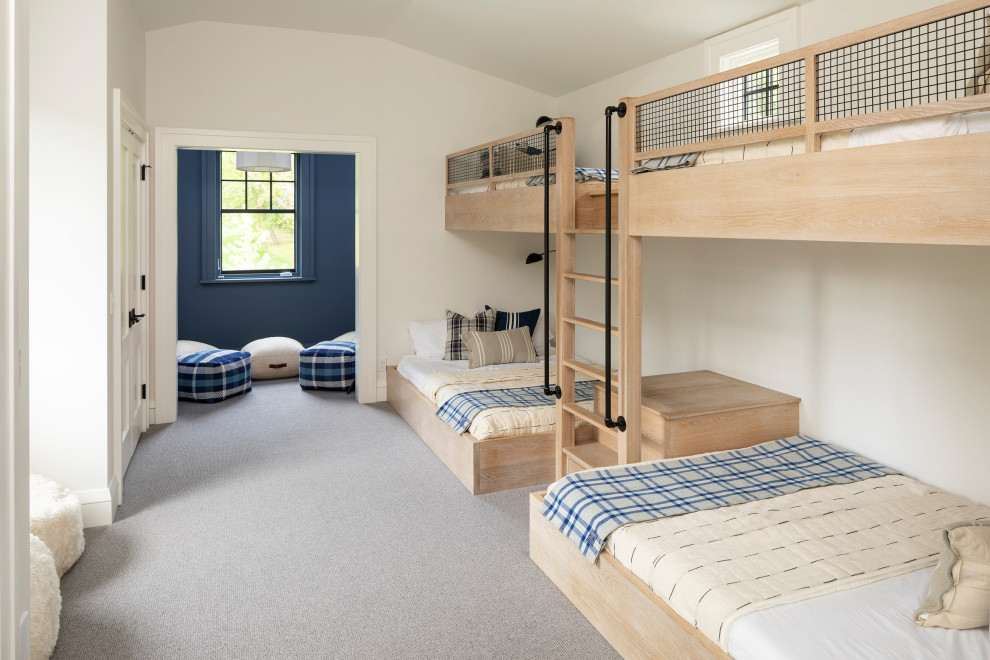 Inredning av ett klassiskt könsneutralt barnrum kombinerat med sovrum och för 4-10-åringar, med vita väggar, heltäckningsmatta och grått golv