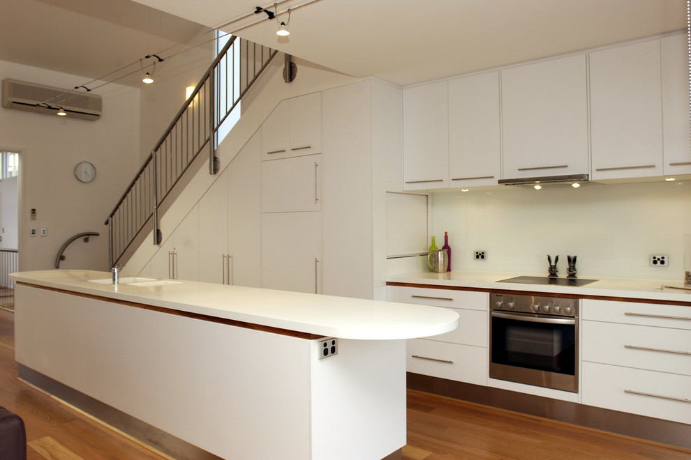 Contemporary kitchen in Adelaide with flat-panel cabinets and white cabinets.
