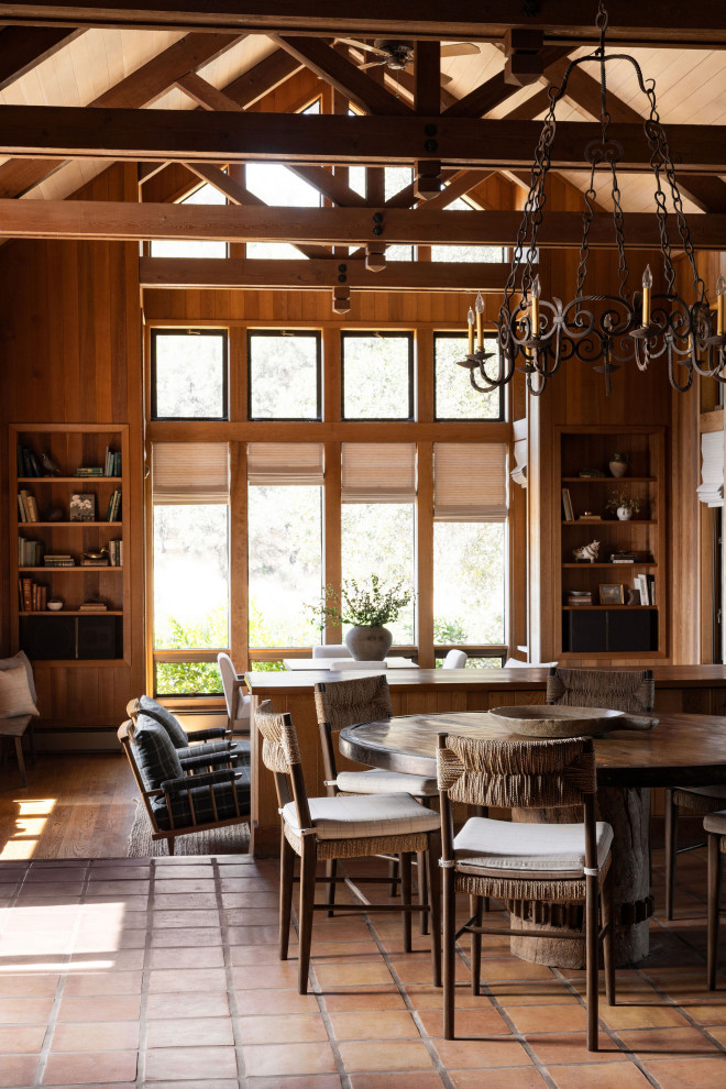 Идея дизайна: кухня-столовая в стиле рустика с коричневыми стенами, полом из терракотовой плитки, красным полом, балками на потолке, сводчатым потолком, деревянным потолком и деревянными стенами