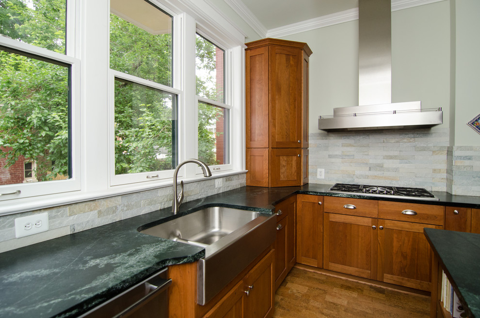 Photo of a traditional kitchen in DC Metro with a farmhouse sink, shaker cabinets, medium wood cabinets, soapstone benchtops and stone tile splashback.