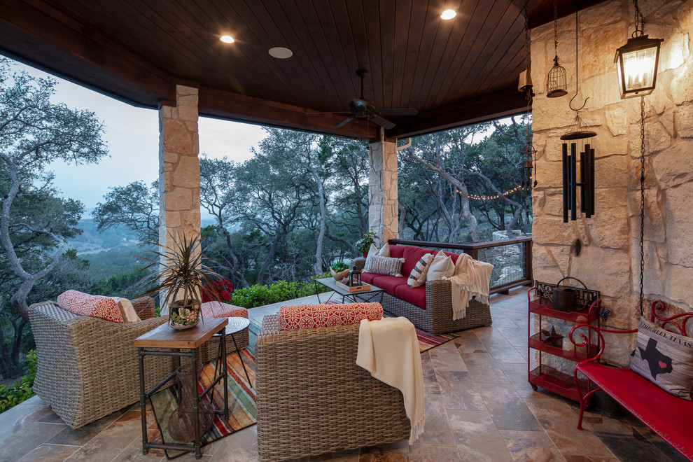 Photo of a mid-sized country backyard patio in Austin with an outdoor kitchen, tile and a roof extension.