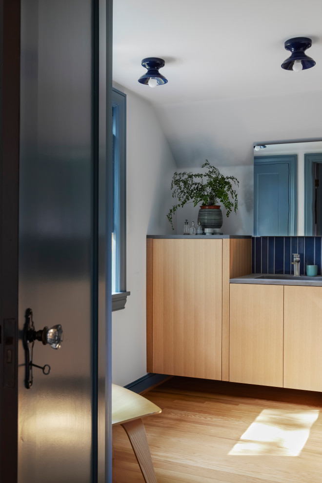 Cette photo montre une salle de bain principale en bois clair avec un placard à porte plane, parquet clair, meuble simple vasque et meuble-lavabo suspendu.