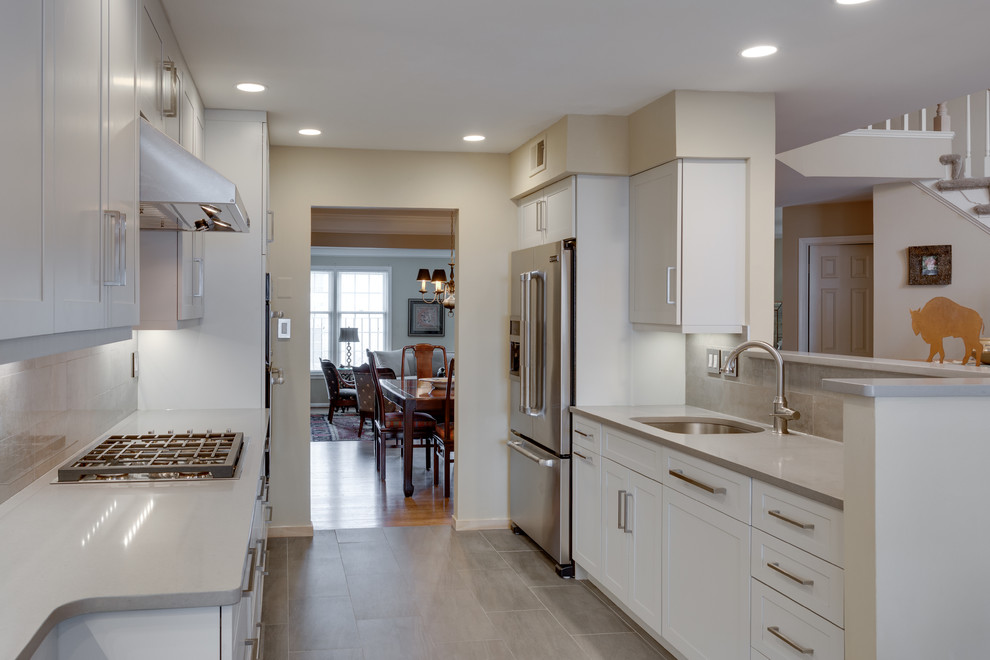 Design ideas for a mid-sized modern galley separate kitchen in DC Metro with an undermount sink, shaker cabinets, grey cabinets, quartz benchtops, beige splashback, stainless steel appliances and a peninsula.