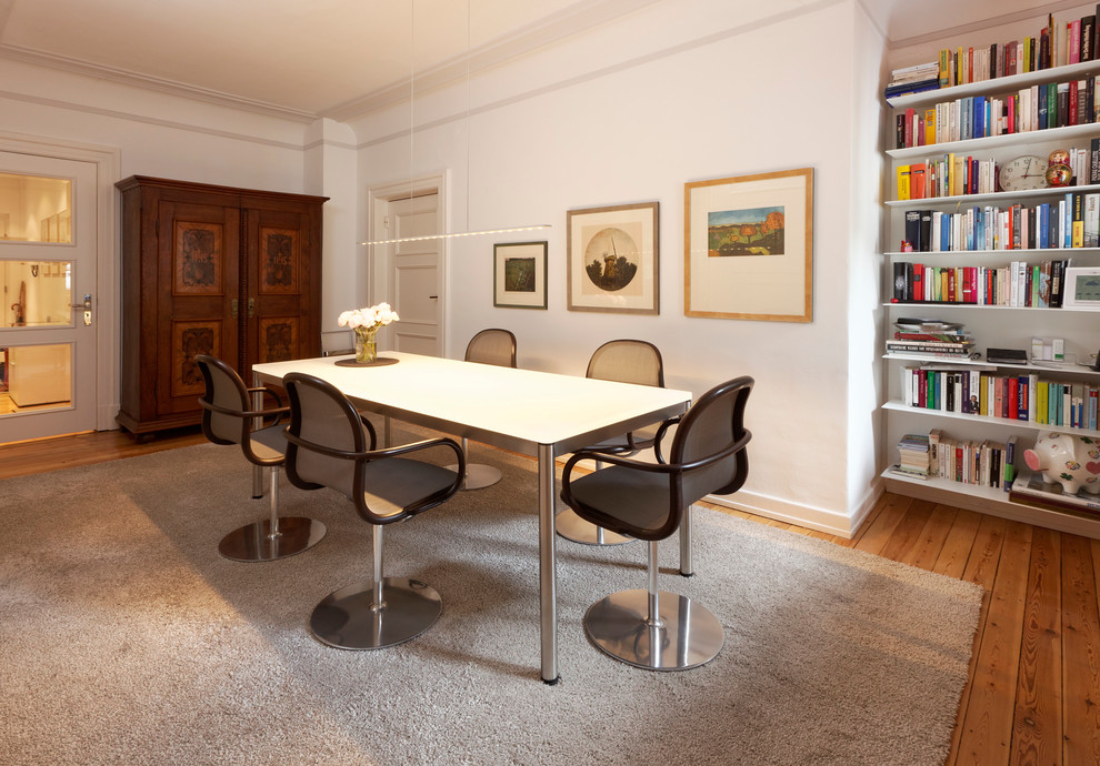 Geschlossenes, Großes Modernes Esszimmer mit weißer Wandfarbe und braunem Holzboden in Hamburg
