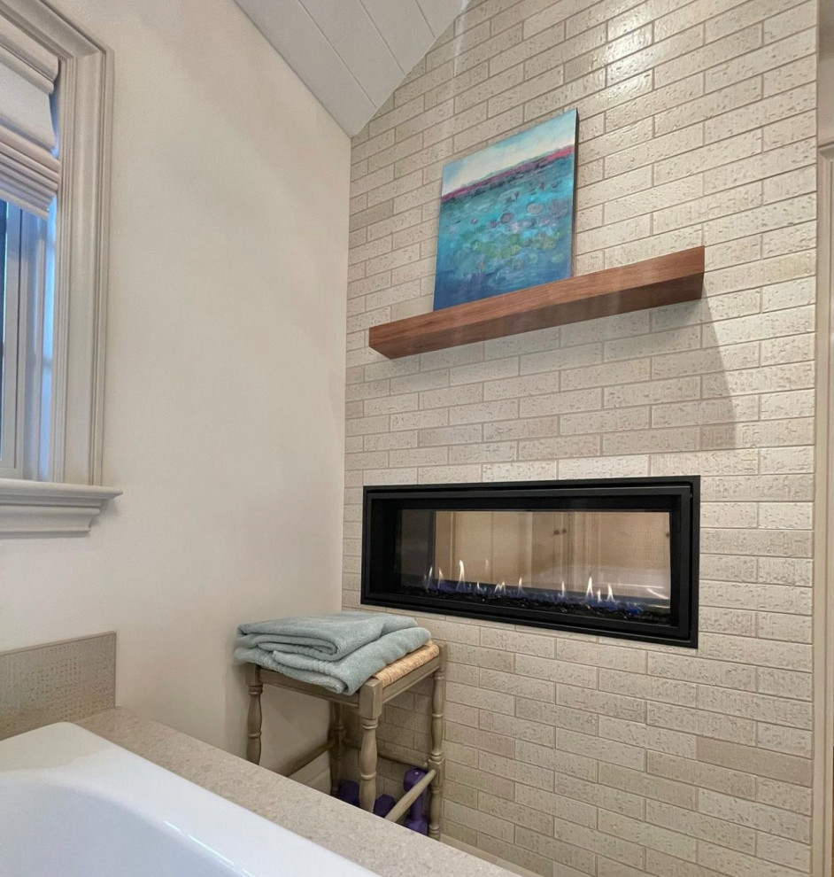 Photo of a large transitional master bathroom in Portland with louvered cabinets, white cabinets, a drop-in tub, a curbless shower, a bidet, beige tile, porcelain tile, white walls, porcelain floors, an undermount sink, granite benchtops, beige floor, a hinged shower door, beige benchtops, a niche, a double vanity, a built-in vanity and vaulted.