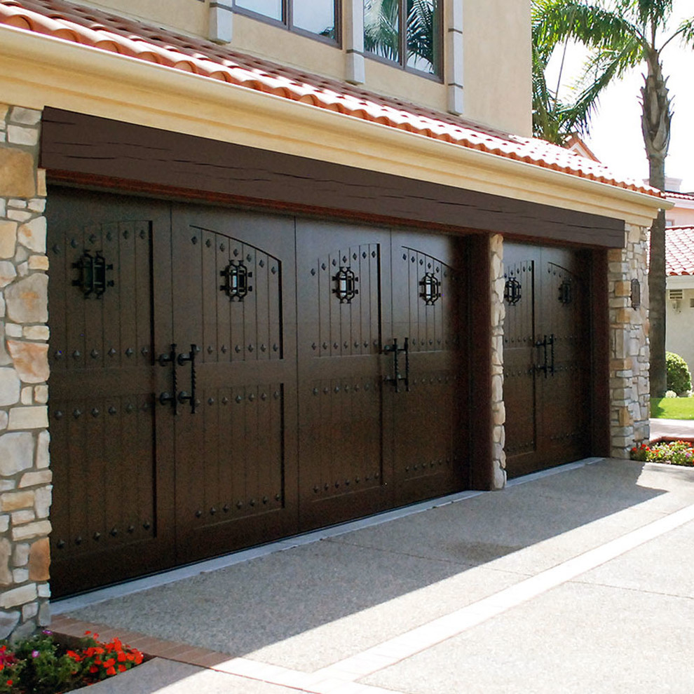 Inspiration for a large mediterranean attached three-car garage in Orange County.