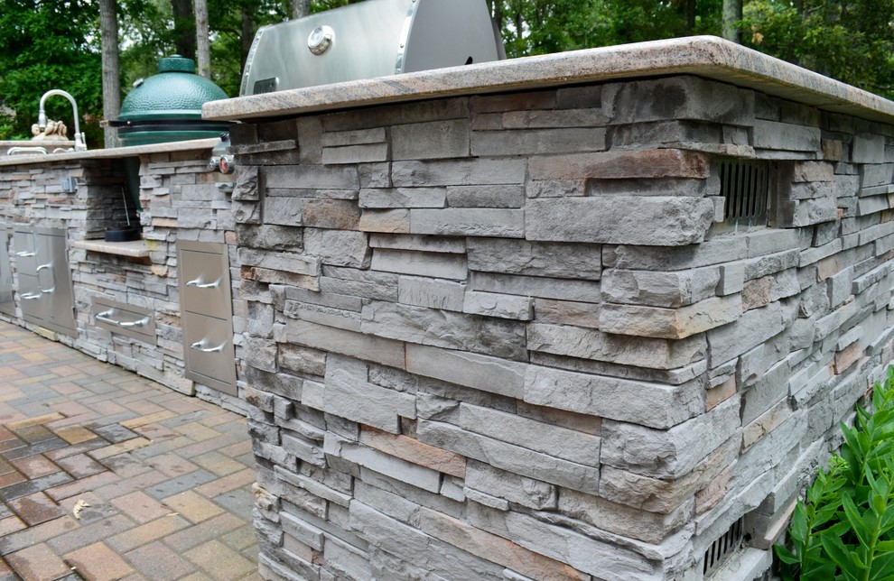 Photo of a transitional backyard patio in DC Metro with an outdoor kitchen and concrete pavers.