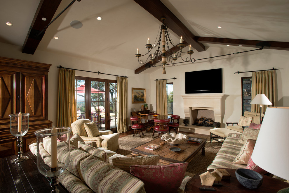 Photo of a large traditional living room in San Francisco with beige walls, terra-cotta floors, a standard fireplace, a concrete fireplace surround and a built-in media wall.