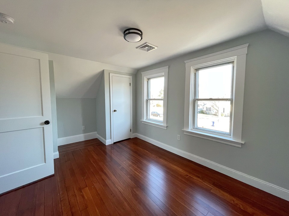 Photo of a small nautical guest bedroom in Providence with green walls and dark hardwood flooring.