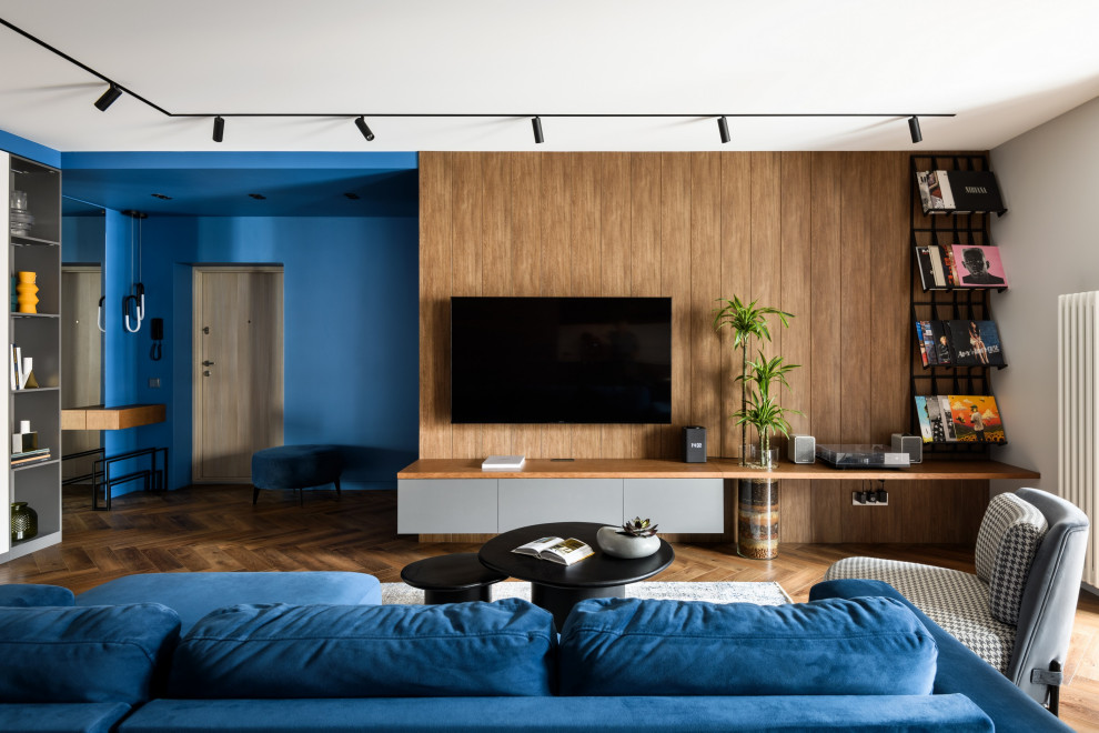 Inredning av ett modernt mellanstort vardagsrum, med ett musikrum, blå väggar, mellanmörkt trägolv och en väggmonterad TV