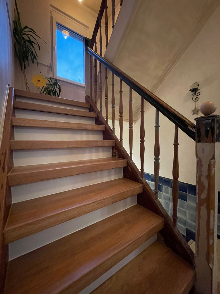 На фото: прямая деревянная лестница среднего размера в стиле шебби-шик с крашенными деревянными ступенями, деревянными перилами и обоями на стенах с