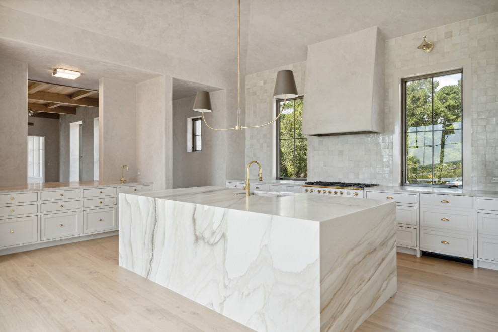 Eat-in kitchen - modern l-shaped light wood floor and vaulted ceiling eat-in kitchen idea in Charleston with an undermount sink, shaker cabinets, beige cabinets, marble countertops, beige backsplash, terra-cotta backsplash, paneled appliances and an island