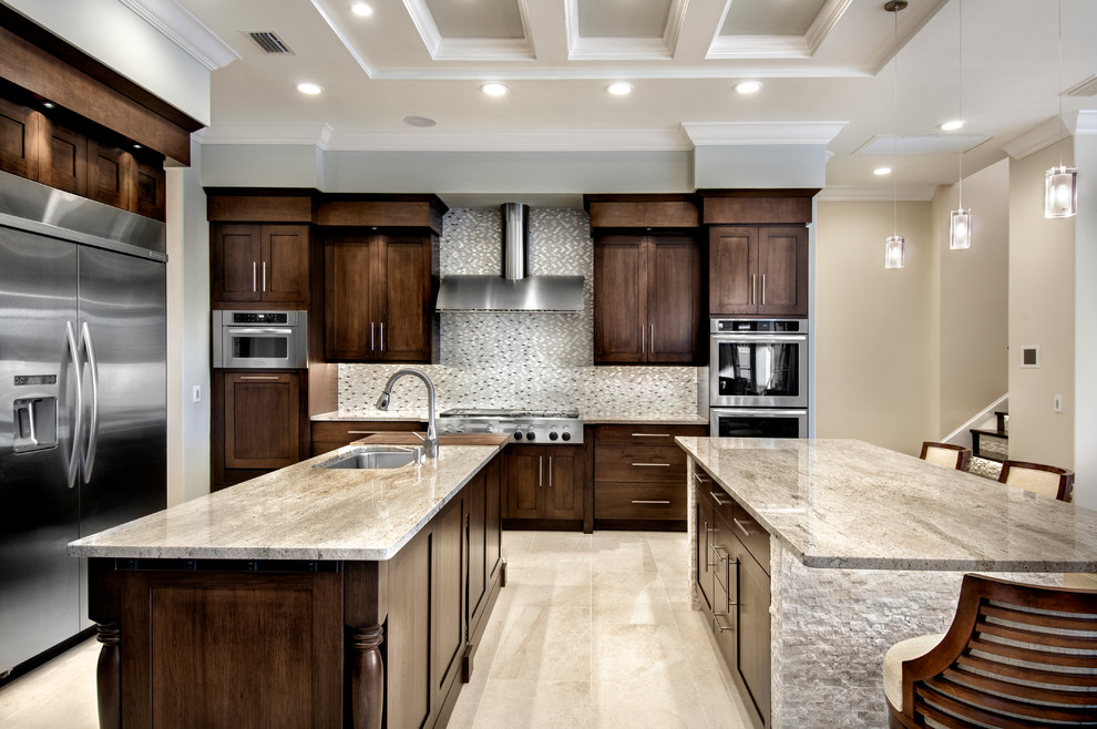This is an example of a mid-sized traditional u-shaped open plan kitchen in Tampa with an undermount sink, shaker cabinets, dark wood cabinets, granite benchtops, multi-coloured splashback, mosaic tile splashback, stainless steel appliances, ceramic floors and multiple islands.