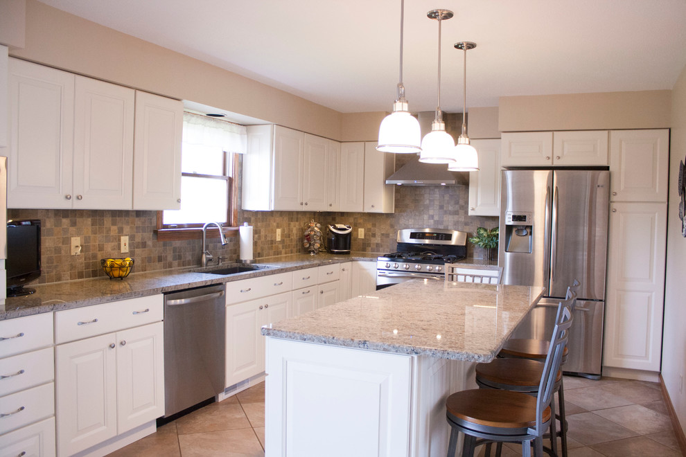 Inspiration for a mid-sized transitional l-shaped porcelain tile enclosed kitchen remodel with an undermount sink, raised-panel cabinets, white cabinets, granite countertops, gray backsplash, porcelain backsplash, stainless steel appliances and an island
