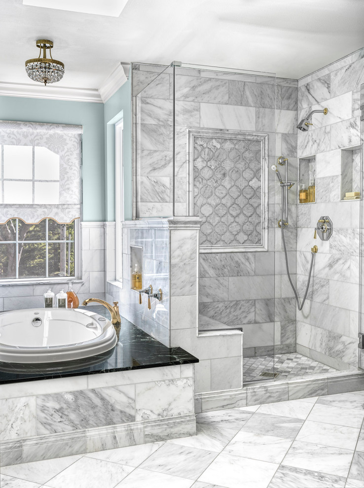 This is an example of a mid-sized traditional master bathroom in St Louis with raised-panel cabinets, dark wood cabinets, a drop-in tub, an open shower, a bidet, gray tile, marble, blue walls, marble floors, a drop-in sink, marble benchtops, white floor, a hinged shower door, green benchtops, a shower seat, a double vanity and a freestanding vanity.