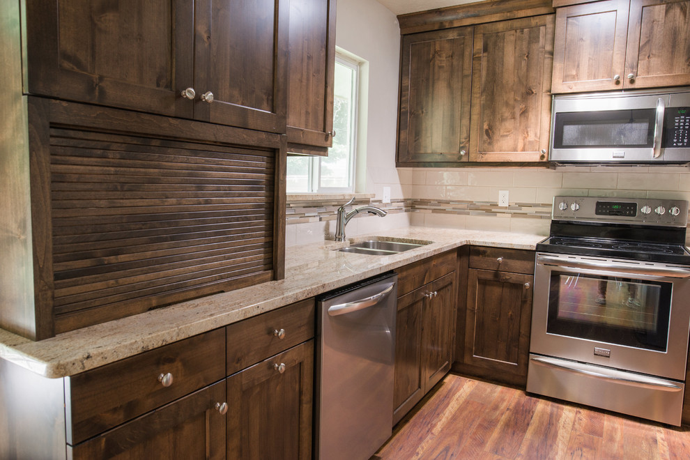 Small traditional l-shaped separate kitchen in Boise with an undermount sink, shaker cabinets, medium wood cabinets, granite benchtops, beige splashback, ceramic splashback, stainless steel appliances, medium hardwood floors and with island.