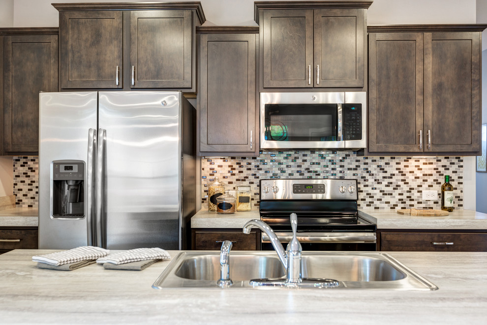 Inspiration for a mid-sized transitional galley kitchen remodel with a double-bowl sink, recessed-panel cabinets, multicolored backsplash, ceramic backsplash, stainless steel appliances and an island