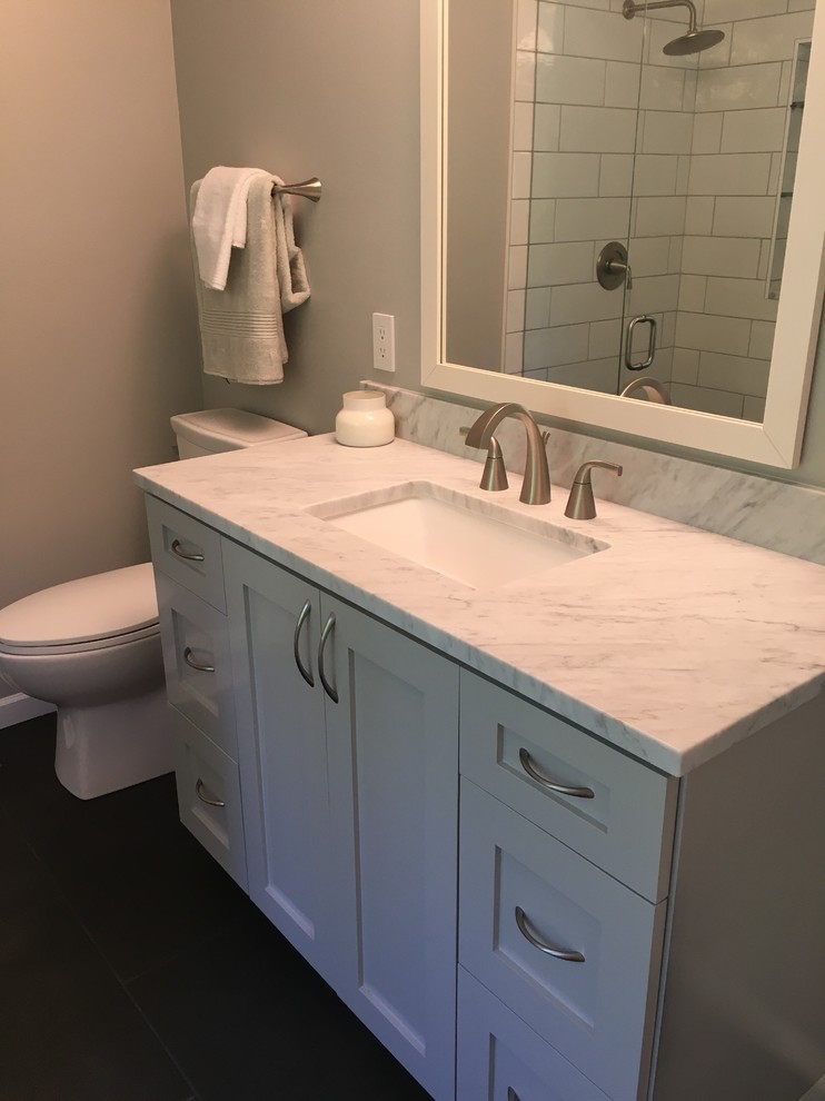 Mid-sized contemporary master bathroom in Seattle with shaker cabinets, grey cabinets, white tile, ceramic tile, engineered quartz benchtops, white benchtops, a corner tub, a corner shower, an undermount sink, a hinged shower door, grey walls, porcelain floors and brown floor.