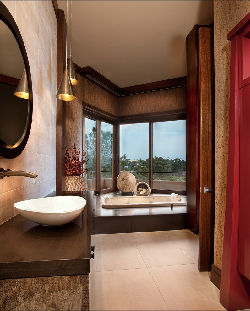 Large asian master bathroom in San Diego with a drop-in tub, beige tile, brown walls, a vessel sink, flat-panel cabinets, dark wood cabinets, an alcove shower, a two-piece toilet, limestone, cement tiles, wood benchtops, beige floor and brown benchtops.