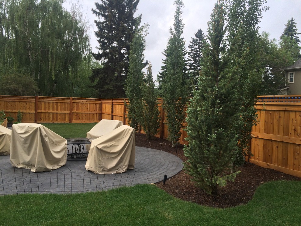 Design ideas for a mid-sized traditional backyard garden in Calgary with brick pavers.