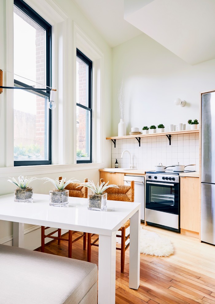 Design ideas for a small scandinavian single-wall eat-in kitchen in Providence with a drop-in sink, flat-panel cabinets, light wood cabinets, wood benchtops, white splashback, porcelain splashback, stainless steel appliances, light hardwood floors, no island and beige floor.