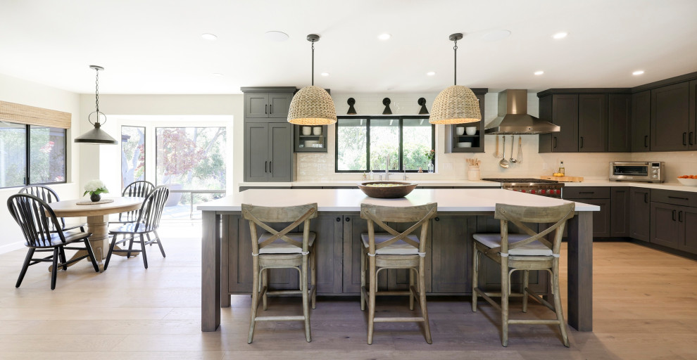 Inspiration for a mid-sized transitional l-shaped laminate floor open concept kitchen remodel with a double-bowl sink, flat-panel cabinets, gray cabinets, quartz countertops, white backsplash, ceramic backsplash, stainless steel appliances, an island and white countertops