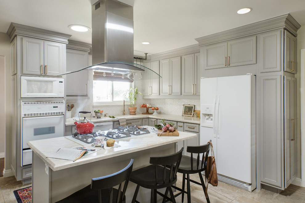 Photo of a mid-sized transitional l-shaped eat-in kitchen in San Diego with recessed-panel cabinets, grey cabinets, quartzite benchtops, white splashback, white appliances, porcelain floors, with island, white floor, white benchtop, a single-bowl sink and mosaic tile splashback.