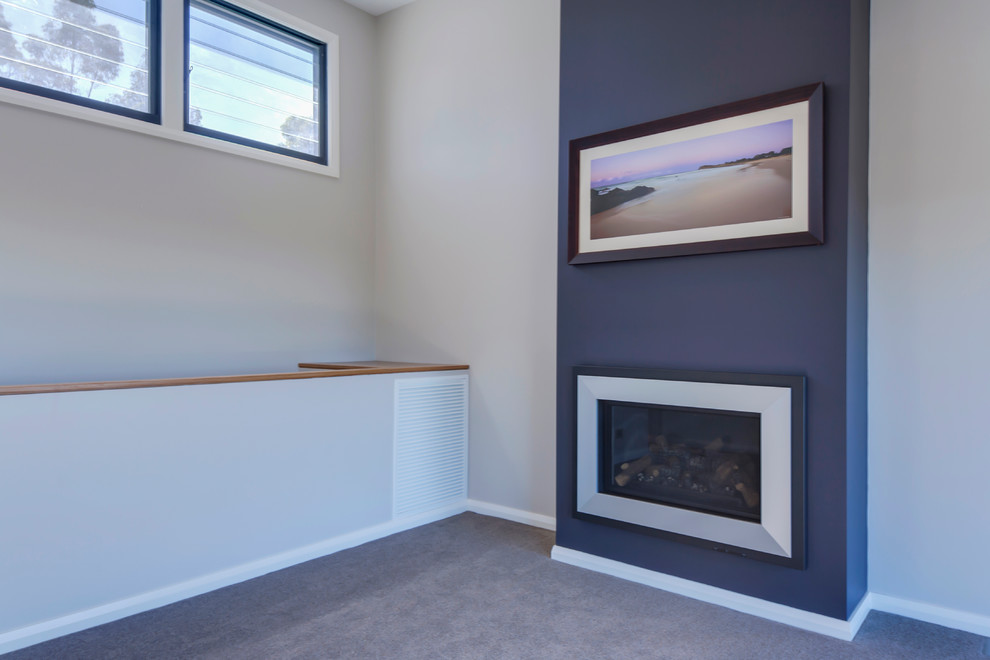 This is an example of a contemporary open concept living room in Sydney with blue walls, carpet, a standard fireplace, a plaster fireplace surround and no tv.