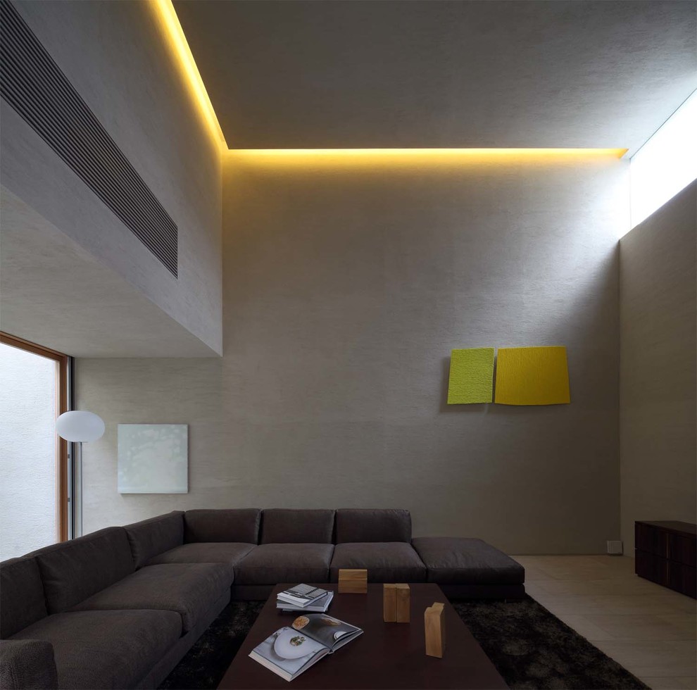 This is an example of a contemporary living room in Osaka with beige walls, limestone floors, a freestanding tv and beige floor.