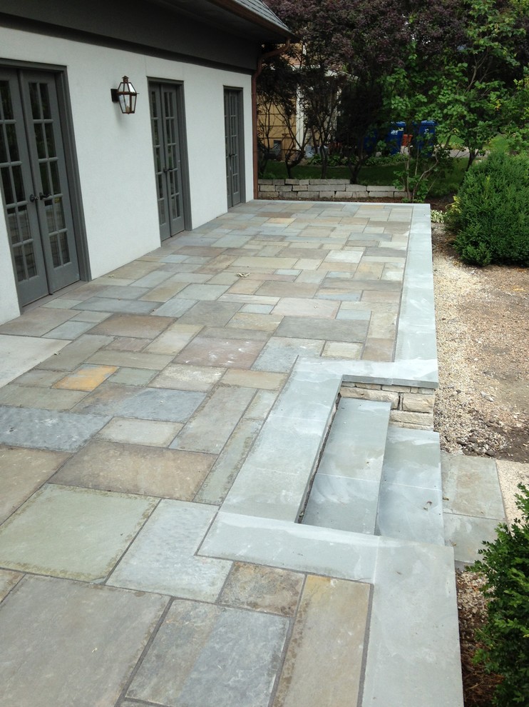 Photo of a large traditional front yard patio in Minneapolis with natural stone pavers.