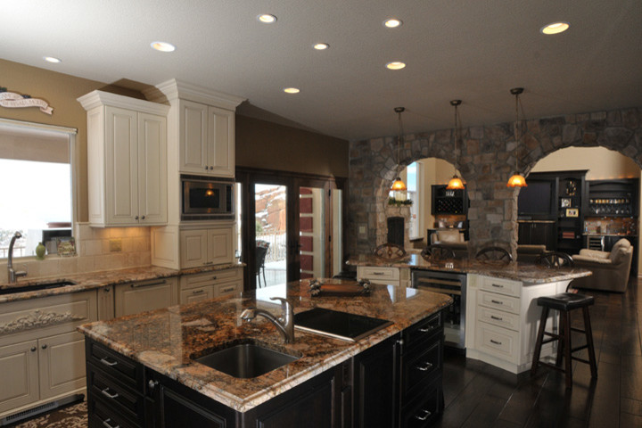 Kitchen - transitional dark wood floor kitchen idea in Denver with white cabinets, granite countertops, beige backsplash, stainless steel appliances and two islands