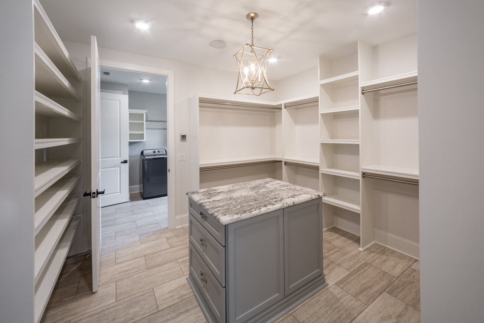 Mid-sized elegant gender-neutral porcelain tile and beige floor walk-in closet photo with recessed-panel cabinets and gray cabinets
