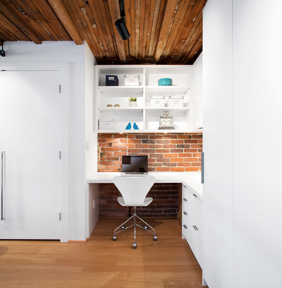 Inspiration for an industrial study room in Vancouver with light hardwood floors and a built-in desk.
