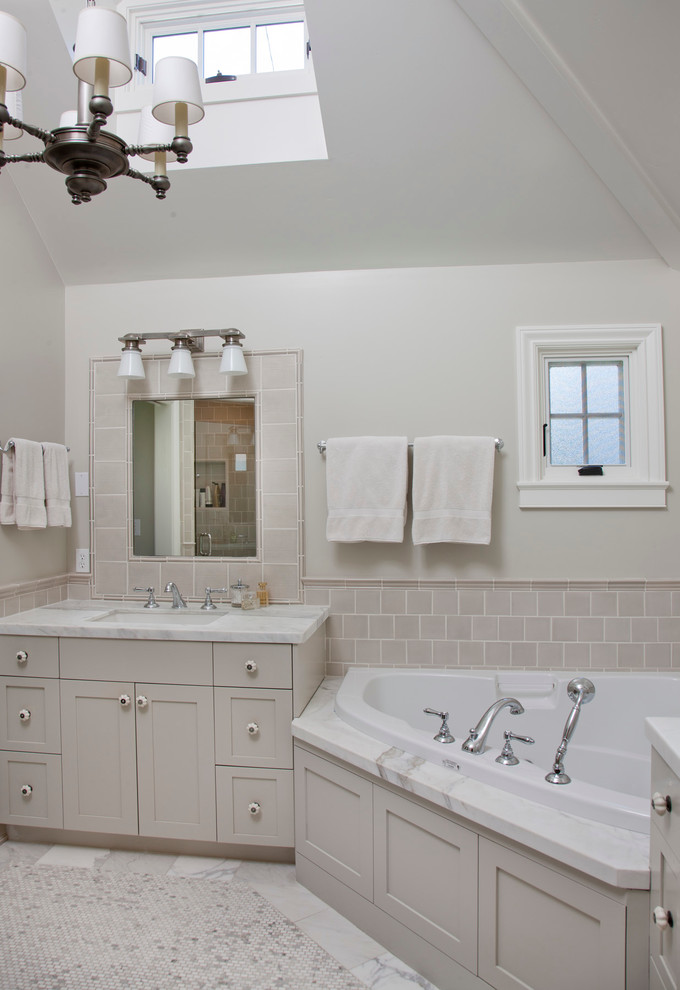 This is an example of a traditional bathroom in San Diego with a corner tub and subway tile.