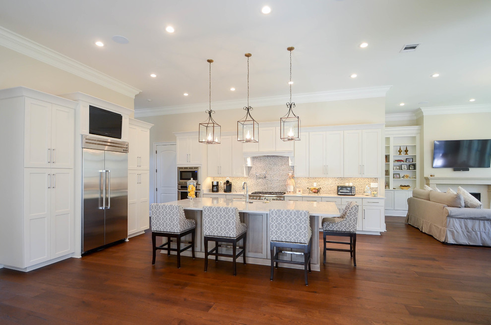 Inspiration for a mid-sized transitional single-wall medium tone wood floor open concept kitchen remodel in New Orleans with a single-bowl sink, recessed-panel cabinets, white cabinets, stainless steel appliances and an island